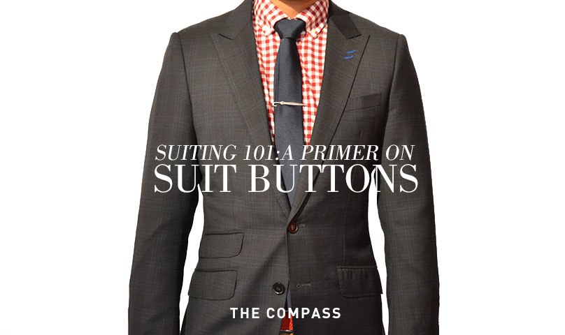 two button suit in warm dark gray and red check shirt with a slate gray tie with text overlay that reads 'suiting 101- a primer on suit buttons'
