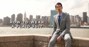 man sitting outside wearing a suit with text reading 'how to wear a plaid suit'