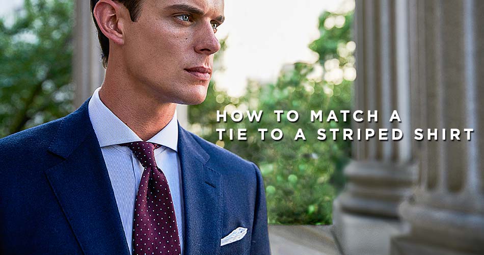 man wearing a white suit and dotted burgundy tie with blue striped shirt with text reading how to match a tie to a striped shirt