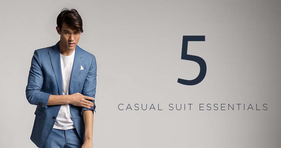 man wearing blue suit with white t-shirt with text "5 casual suit essentials"