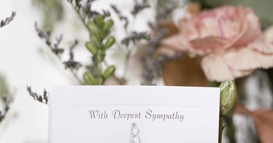 flowers with card that reads "with deep sympathy"