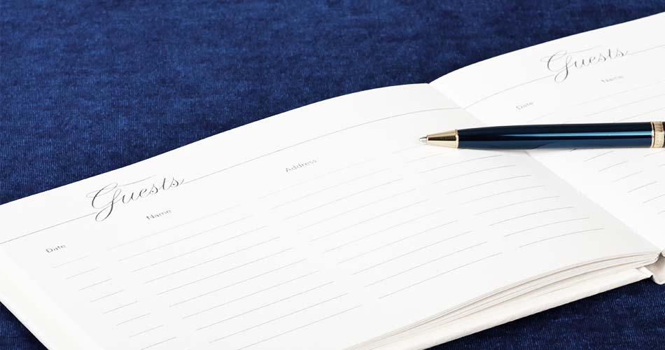 blank open guest book with blue pen on top