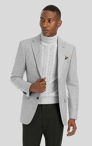 man wearing a knitted gray turtleneck with a gray blazer and black pants