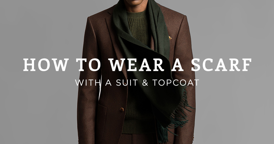 man wearing a brown blazer with green scarf with text overlay 'How to wear a scarf with a suit & topcoat"
