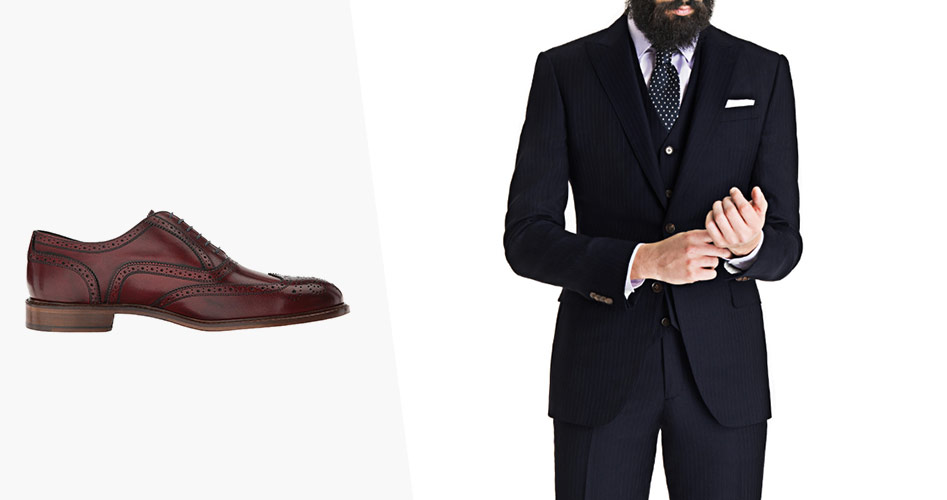 sideview of oxblood dress shoes with a man wearing dark navy three piece suit with navy tie