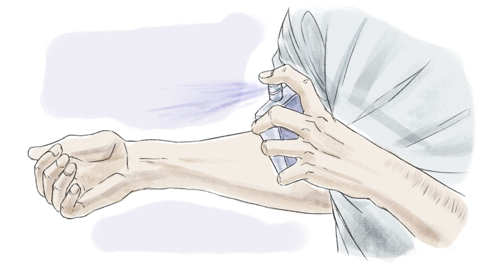 person spraying cologne on wrist