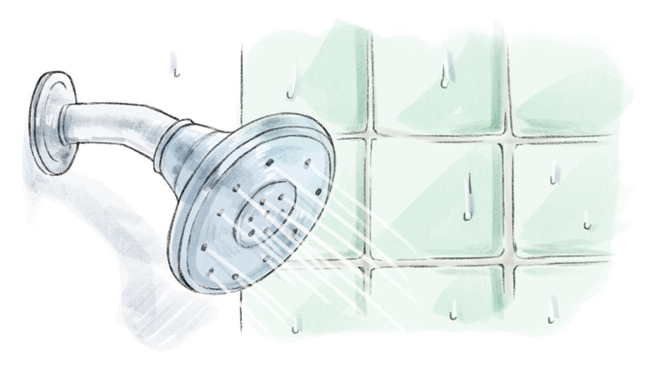 shower head with water coming out and green tiles