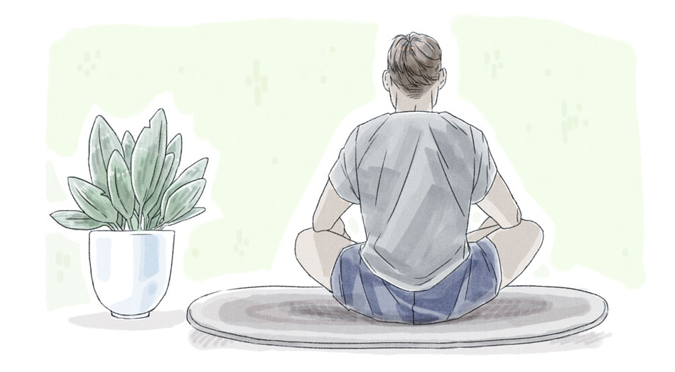 man facing the back wearing gray shirt and blue shorts sitting on a rug and meditating