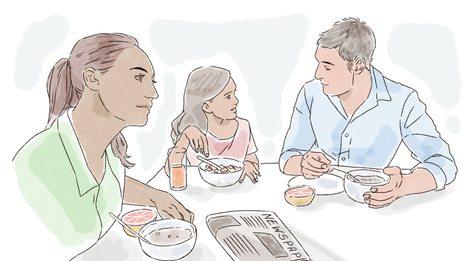 man, woman, and child sitting at a breakfast table