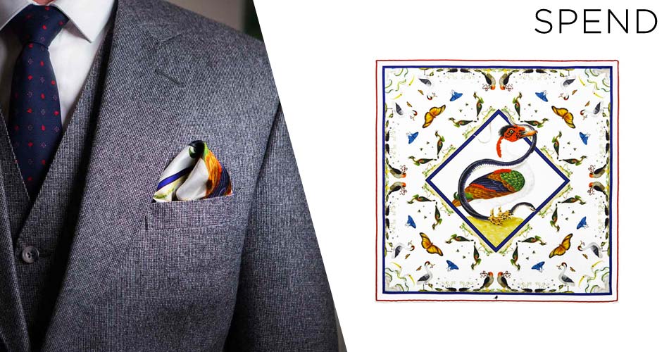 suit accessory pocket square with birds and butterfly illustration on white background and folded into a suit pocket