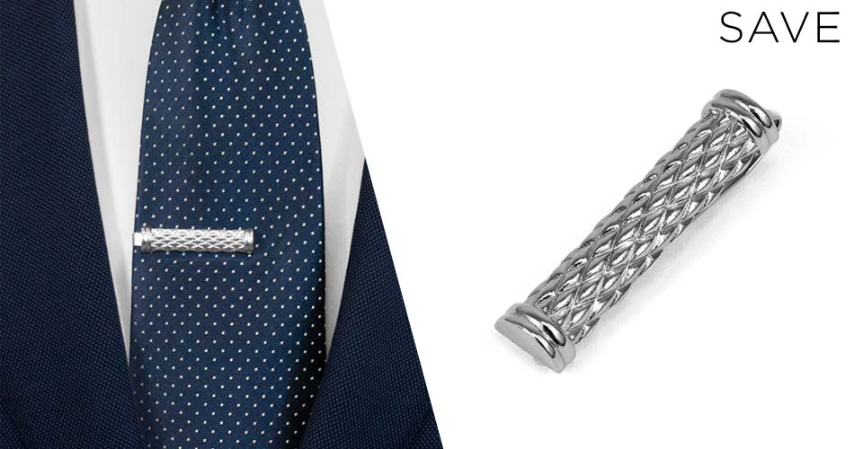 silver textured suit accessory tie clip on a blue dotted tie and on white background