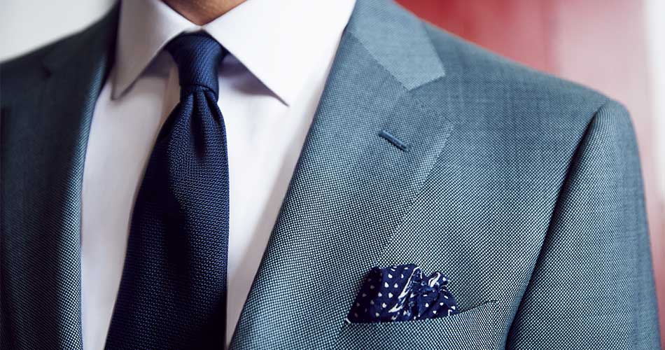 close up of a man wearing navy tie with blue suit and navy pocket square