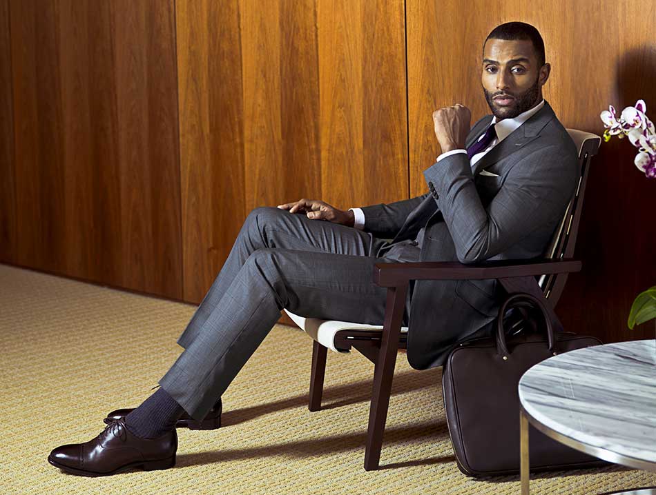 man seated wearing fitted suit jacket and fitted dress pants