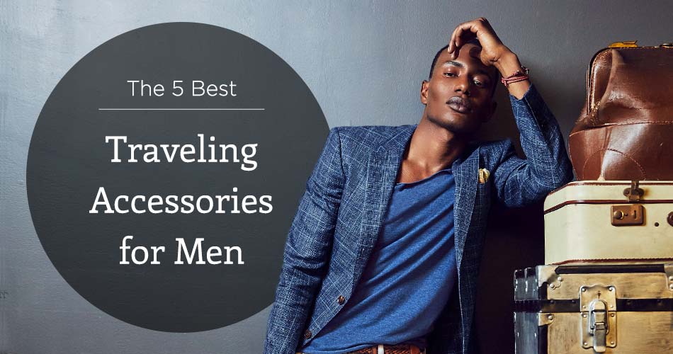 man wearing blue fitted blazer with suit cases with text "The 5 Best Traveling Accessories for Men"